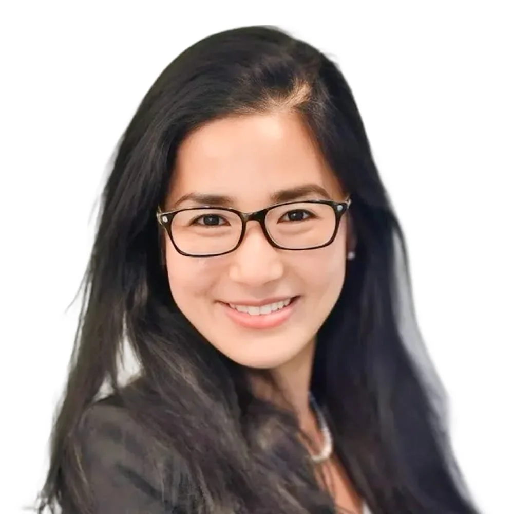 Portrait of a woman with long black hair, wearing glasses, smiling, against a white background.
