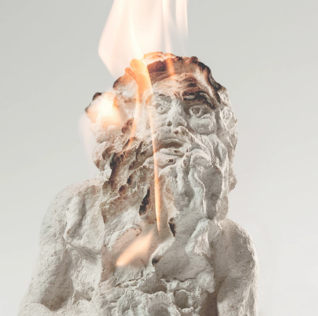 Estátua de tamanho grande com fogo e fumaça saindo do topo.