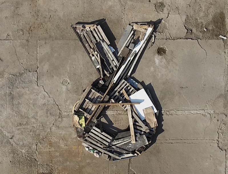 Estrutura de madeira em forma de ovelha apoiada no chão de concreto