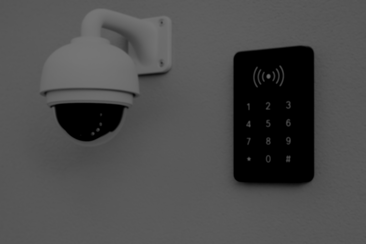 Security camera and electronic access keypad mounted on a wall.