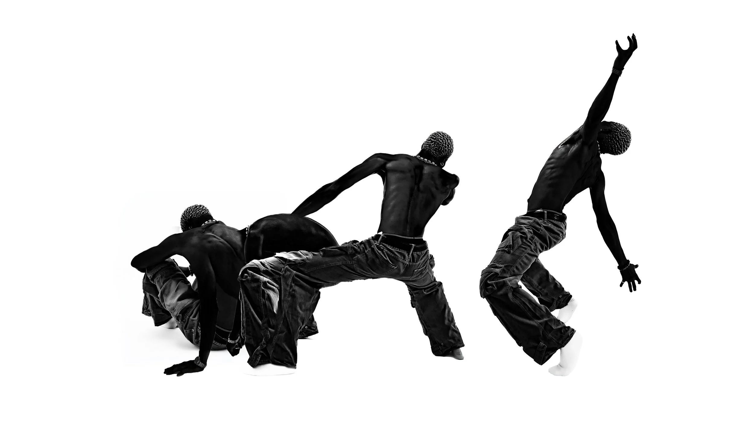 Black-and-white photo of four shirtless men with afro hairstyles performing a dance move, with one man reaching upward and others crouching or leaning.