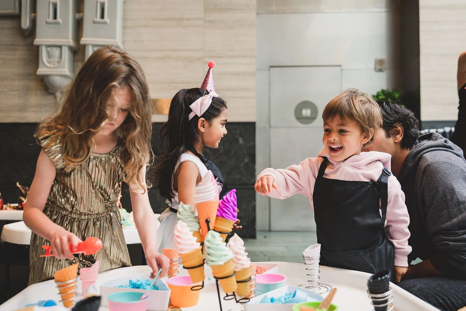 Oogubi Foodie sensory station with children independently playing and parent joyfully observing. 