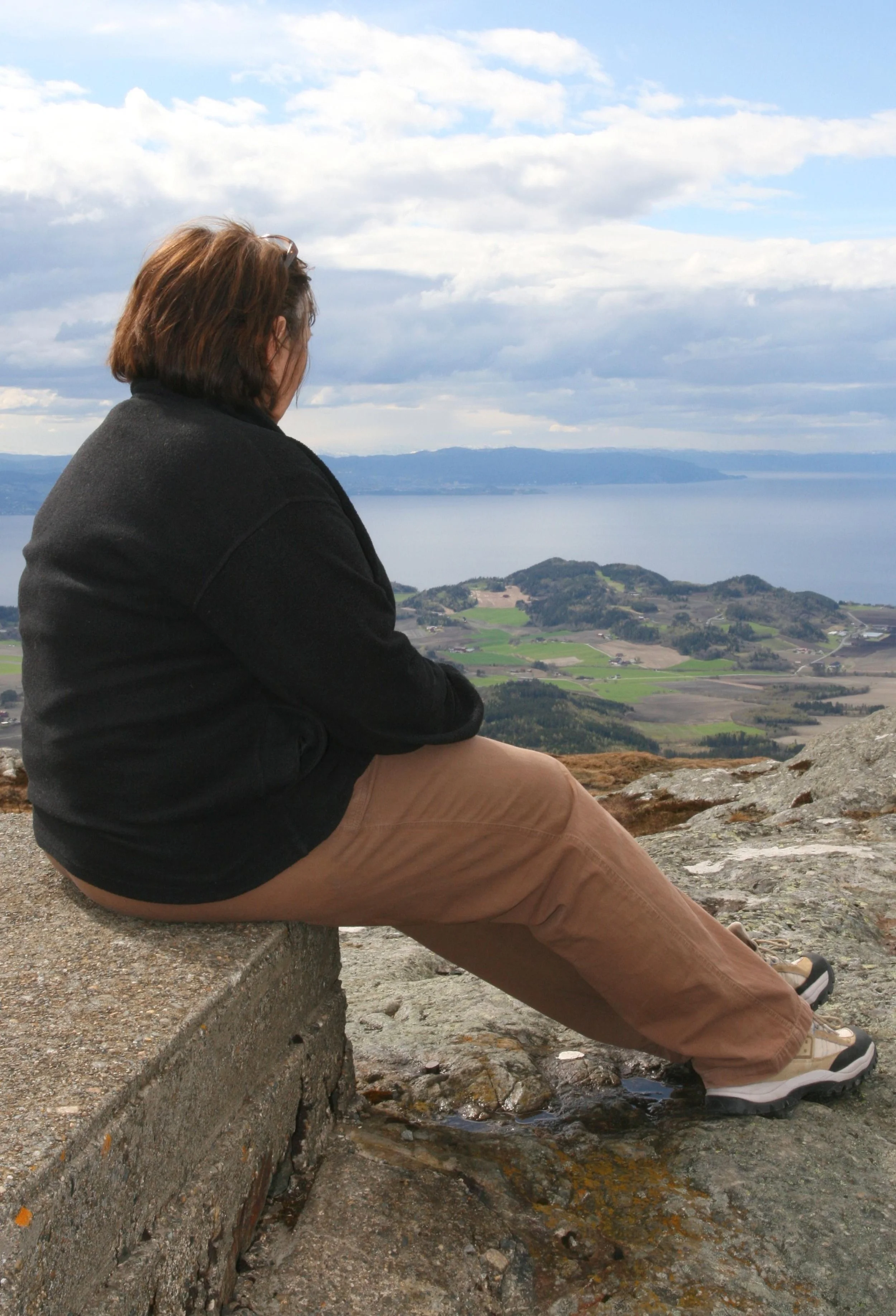 Portrait of woman looking from on high at view of hills and river
