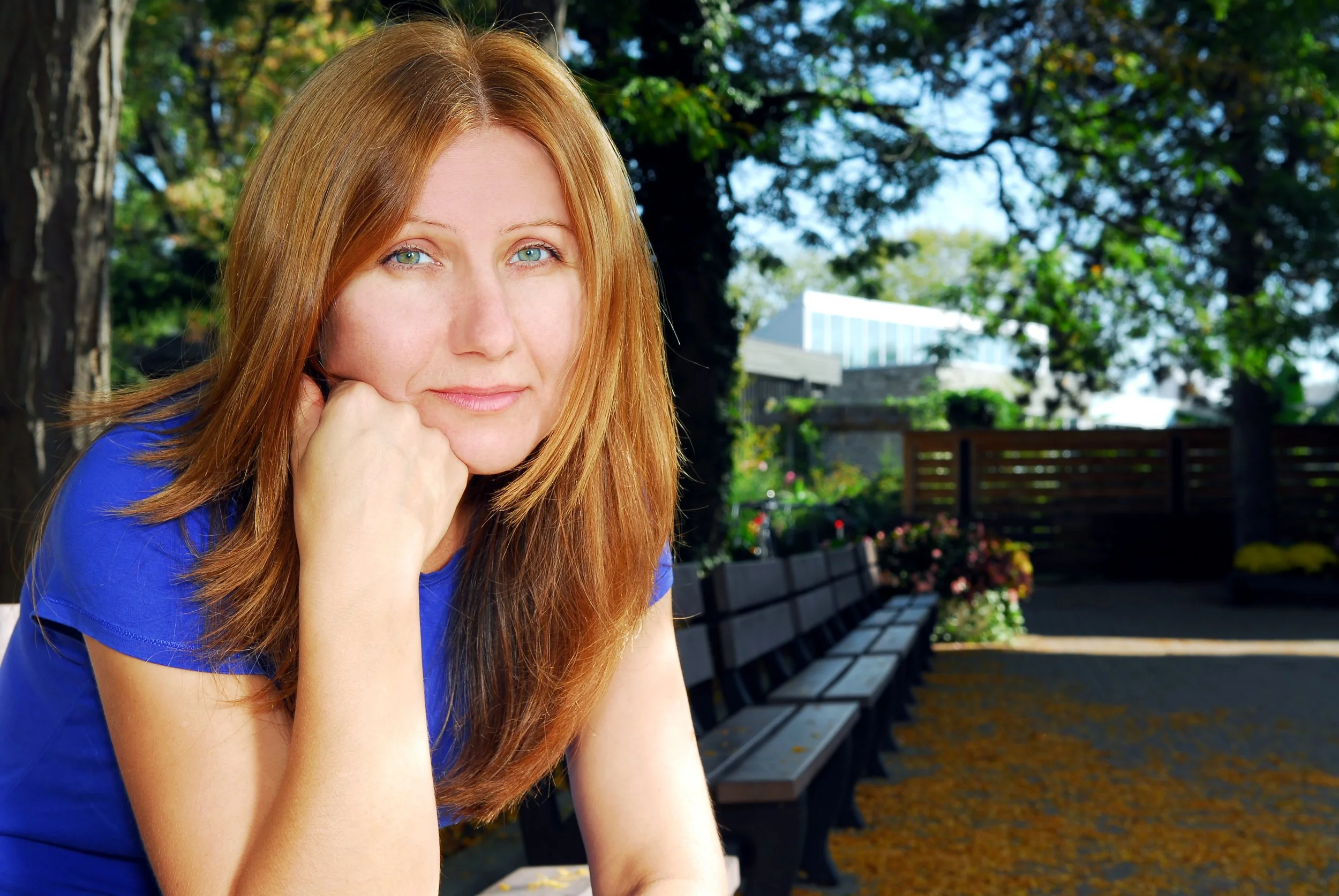 An exhausted mother sitting on park bench waiting for her children to finish their Little League game
