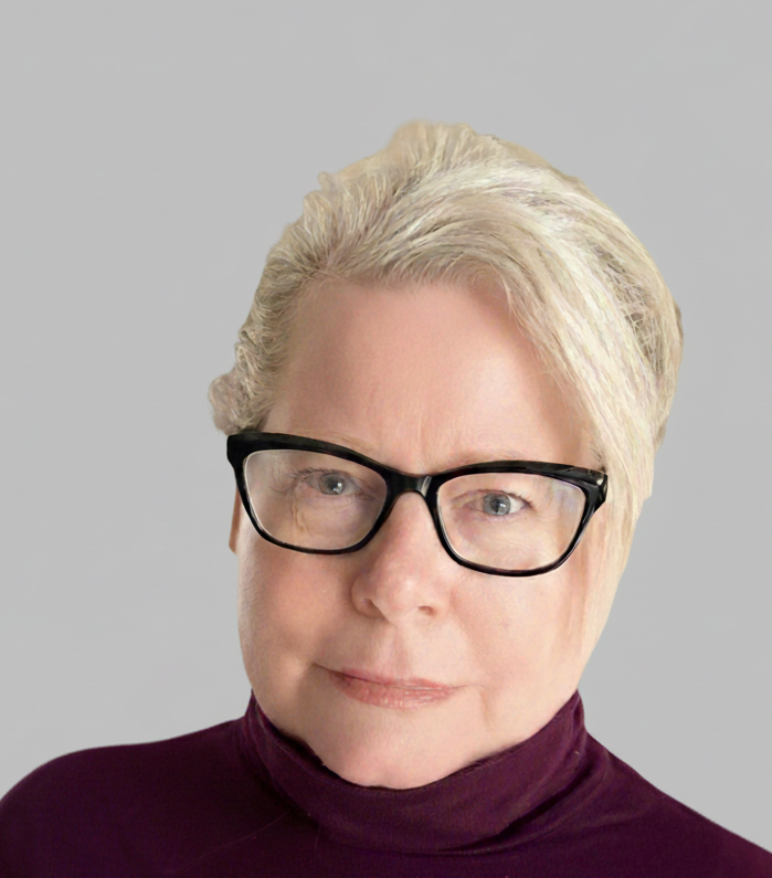 Deborah Pratt, Executive Coach and Consultant. A woman with short blonde hair and glasses, wearing a dark purple turtleneck, posing against a plain gray background.