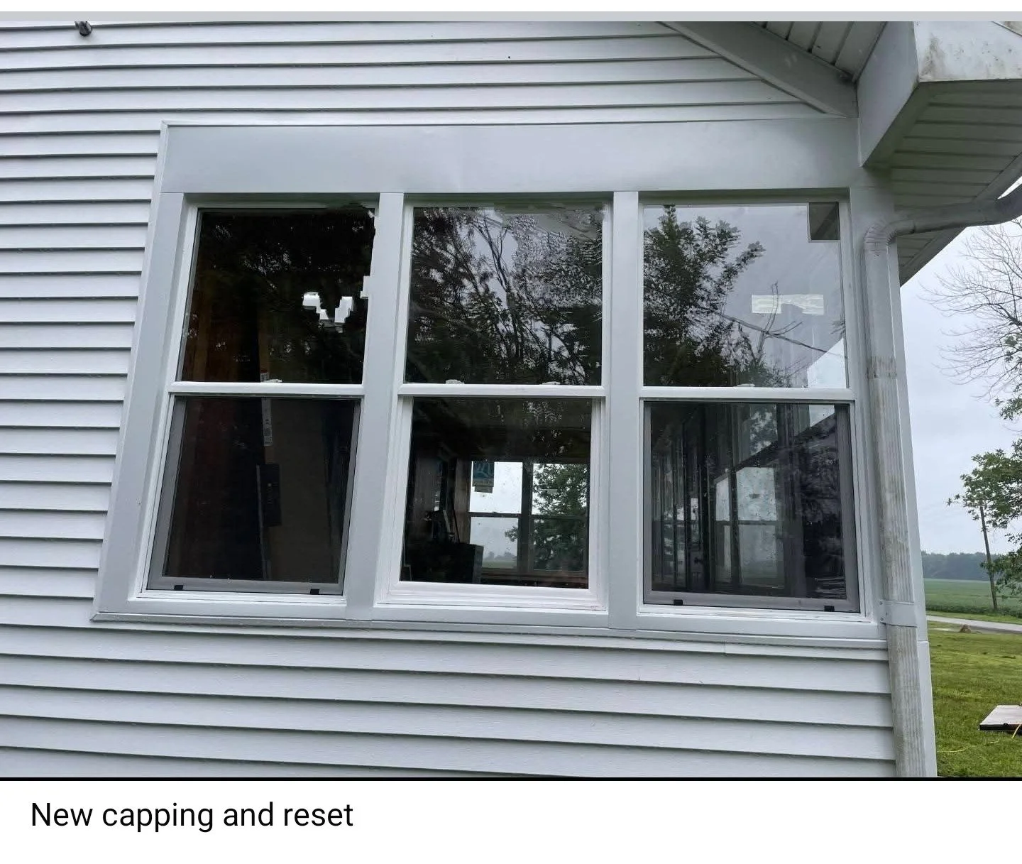 Exterior view of a house with new white window capping and reset window frames on the siding