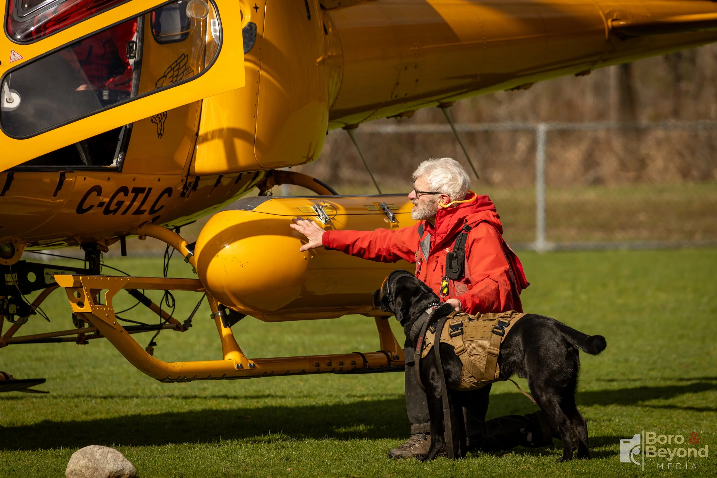 A man with Coquitlam SAR and his K9 partner prepare to board a Talon Helicopter