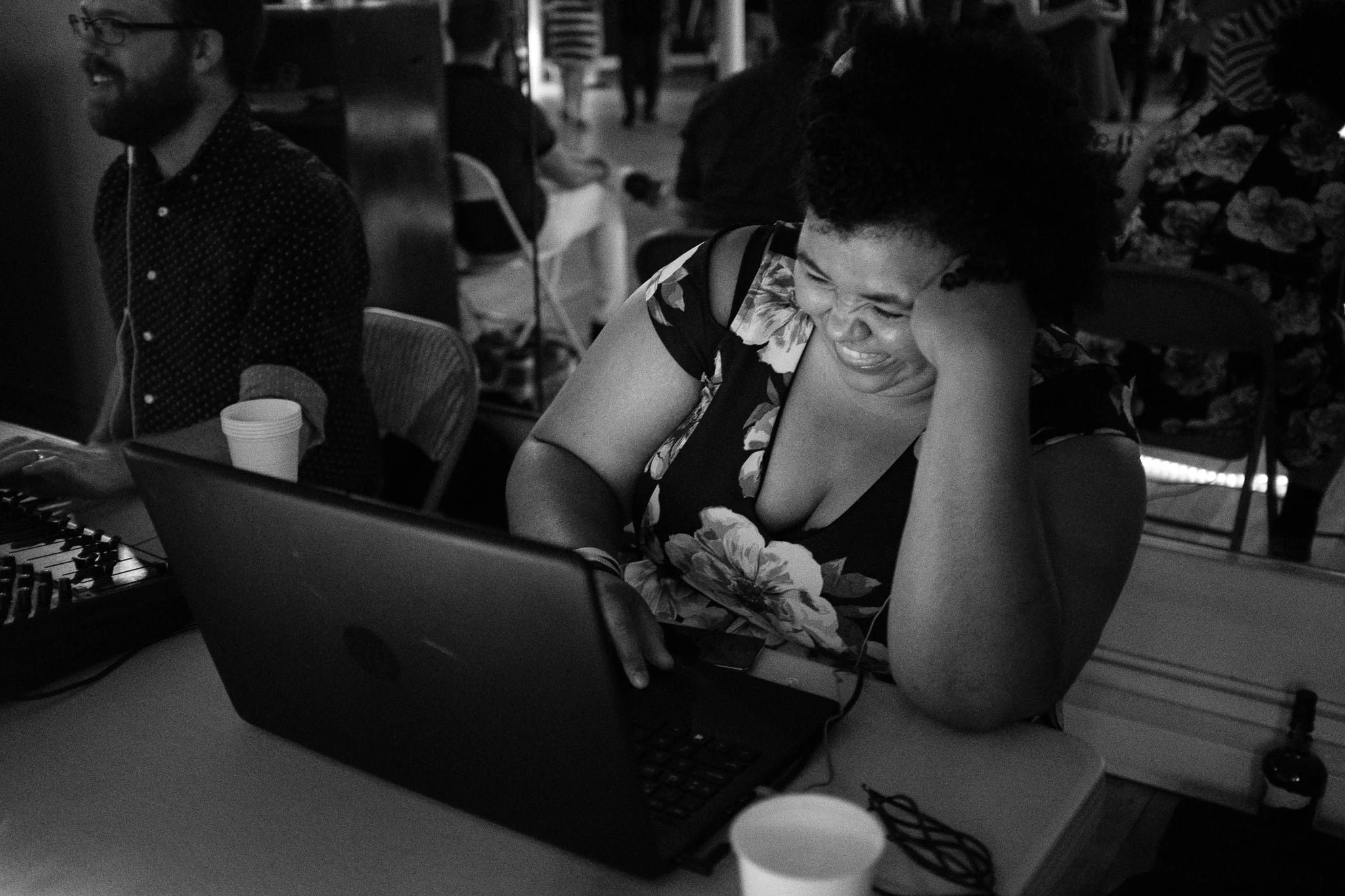 Picture of Brandi smiling while leaning on one elbow in front of her laptop.
