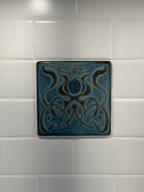  Art Nouveau style decorative tile inset within white subway tile backsplash in custom kitchen renovation. 