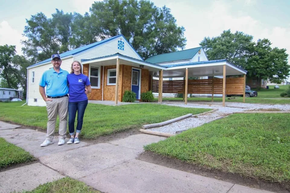 Matt and Amber outside their first remodeled home with a restored porch and fresh exterior and interior updates.