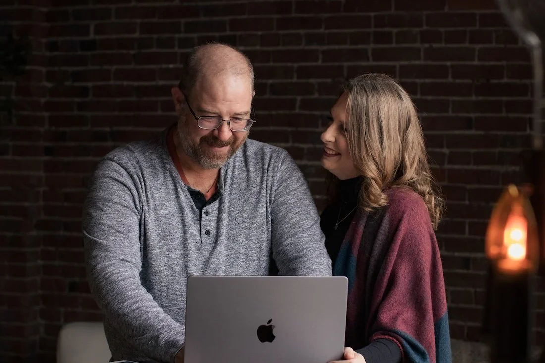 Amber and Matt, founders of Rural Renovation, reviewing renovation plans together at a laptop in a Missouri studio setting