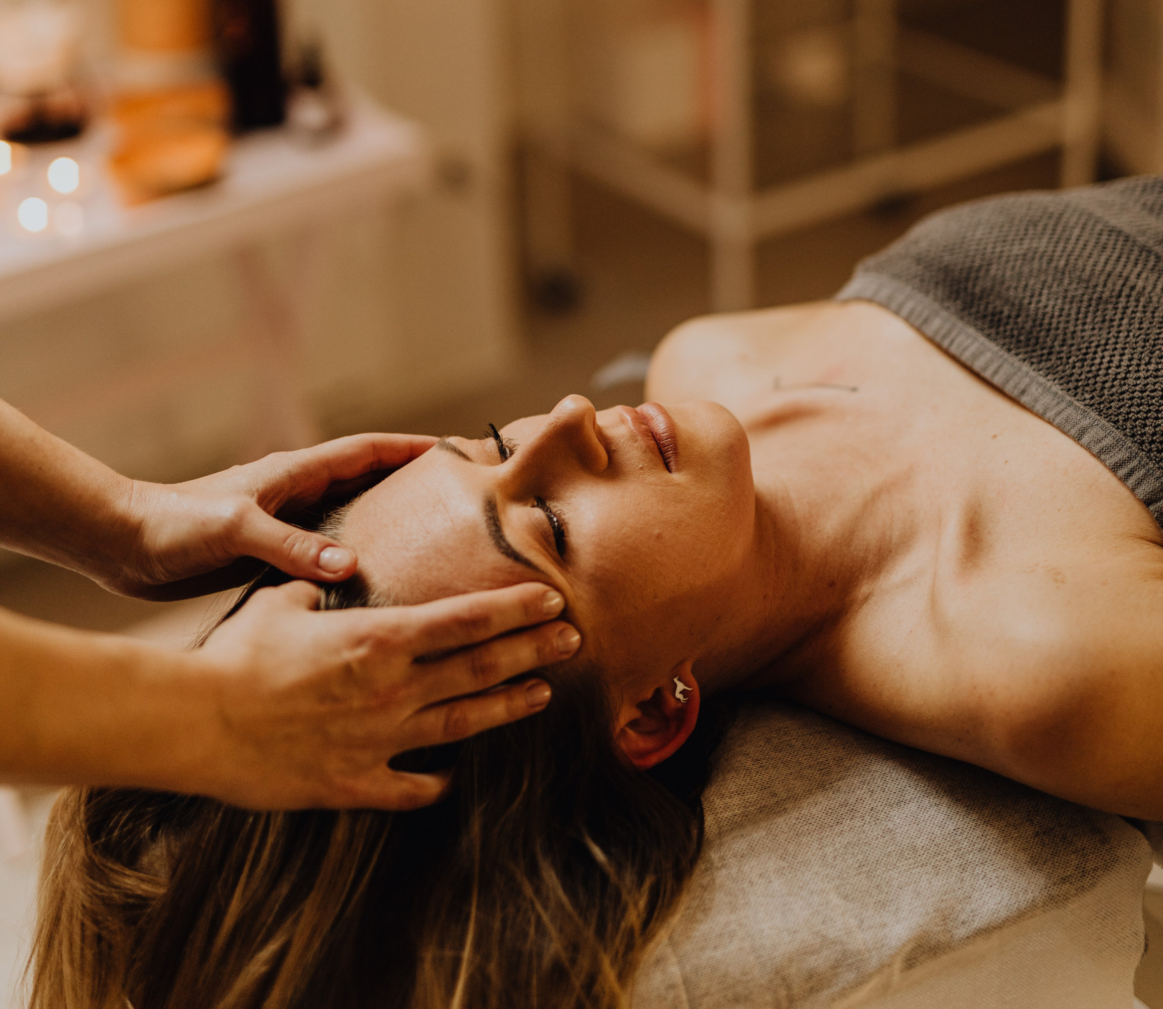 Hands gently placed over woman's third eye chakra.