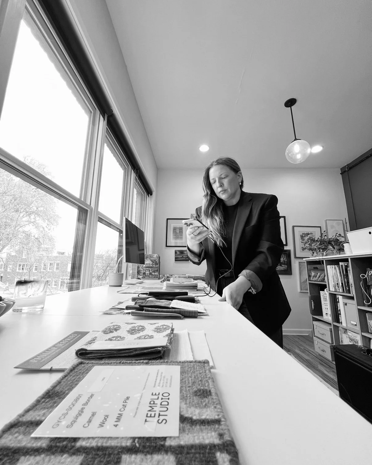 Marketing strategist working at a studio table with creative tools and laptop in a bright workspace