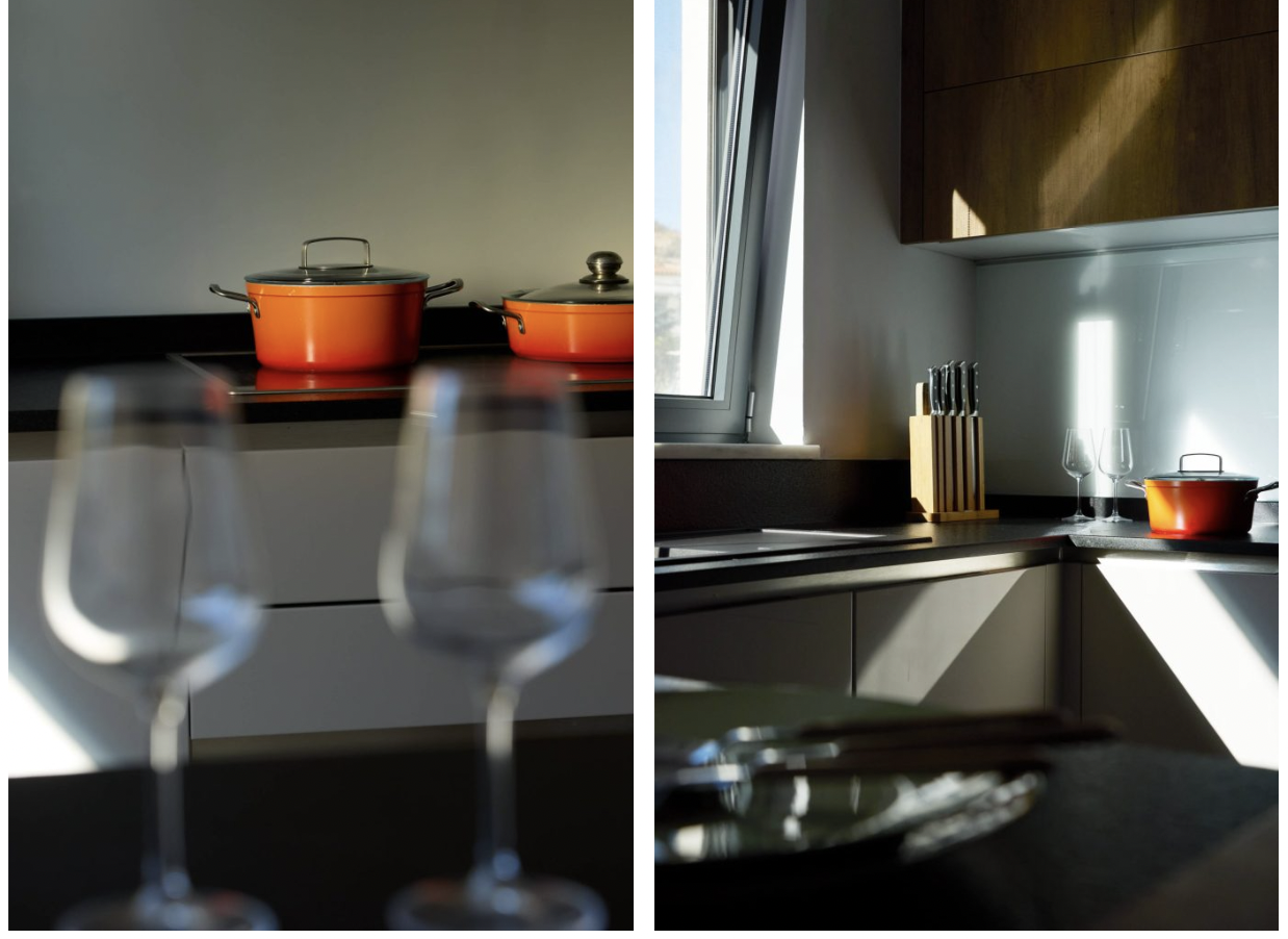 Split view of a modern kitchen with orange pots on the stove and wine glasses on the counter in the foreground.