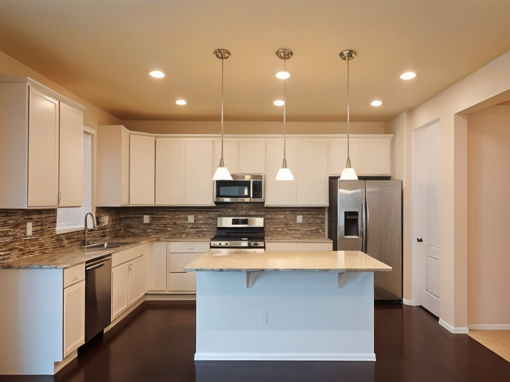Before the Flip and Home Staging: modern kitchen with white cabinets, stainless steel appliances, a central island with a light-colored countertop, three pendant lights, and dark hardwood flooring, showing the space prior to strategic design directio