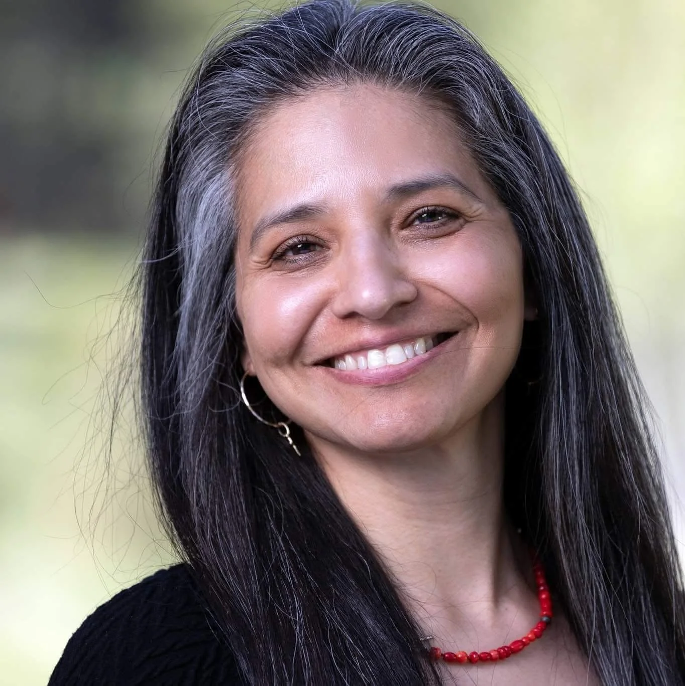 Happy client of Harmony Homes by Amanda, smiling outdoors after using the home staging and design services.