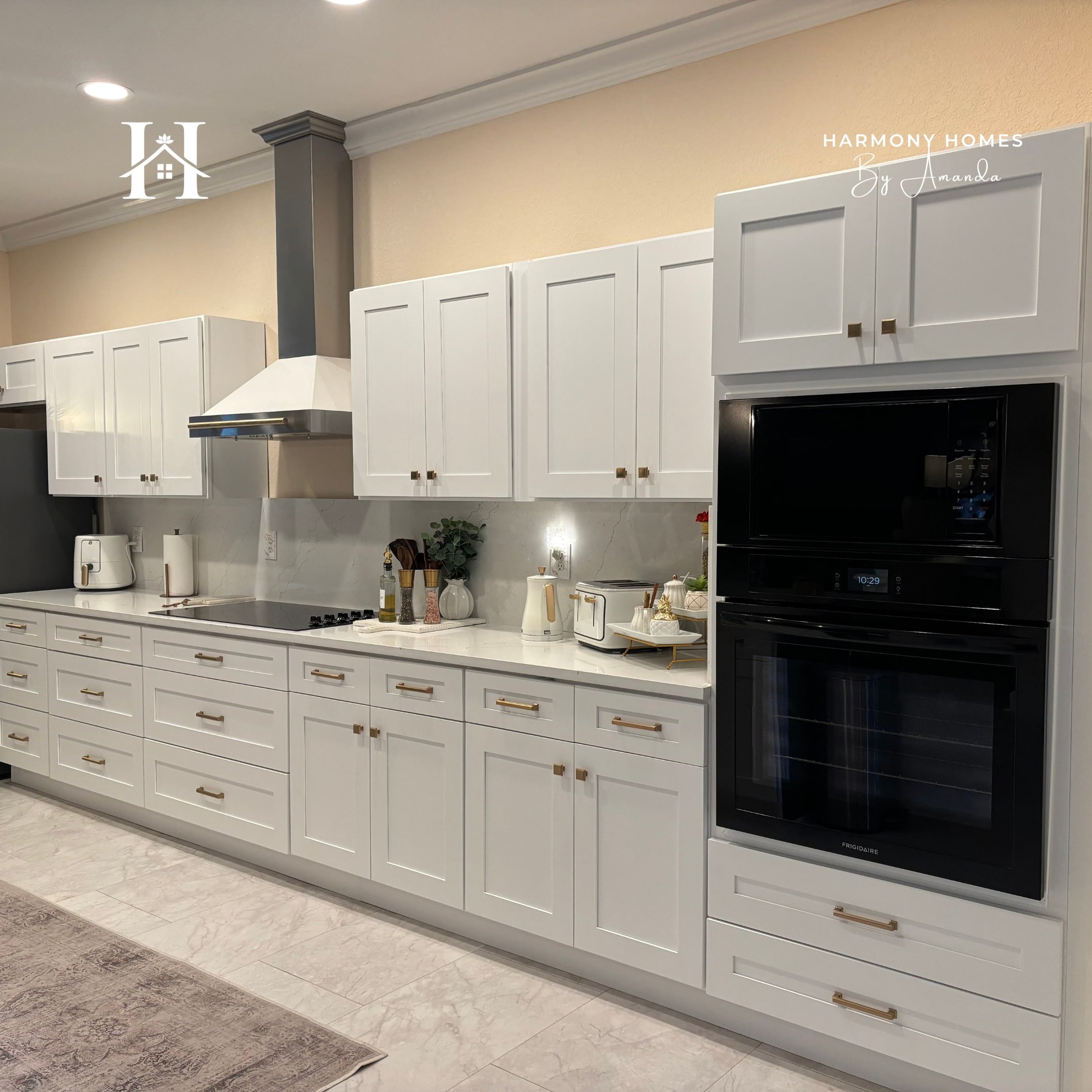 Modern flip design kitchen with white cabinets, black appliances, marble backsplash, and warm beige walls — investor-friendly, ROI-focused finish selection.