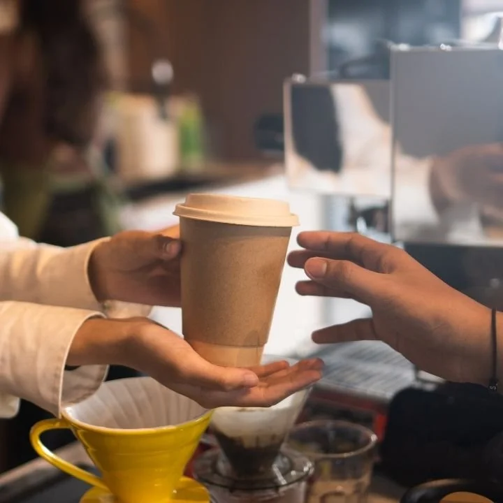 Guest receiving a coffee cup from barista at an event..