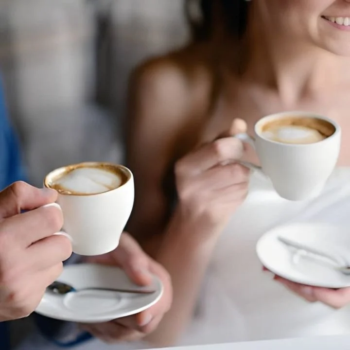 Bride and groom enjoying espresso drinks together at wedding reception.