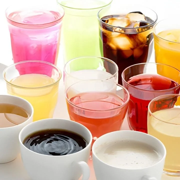 Assorted non-alcoholic drinks displayed in clear glasses and cups.