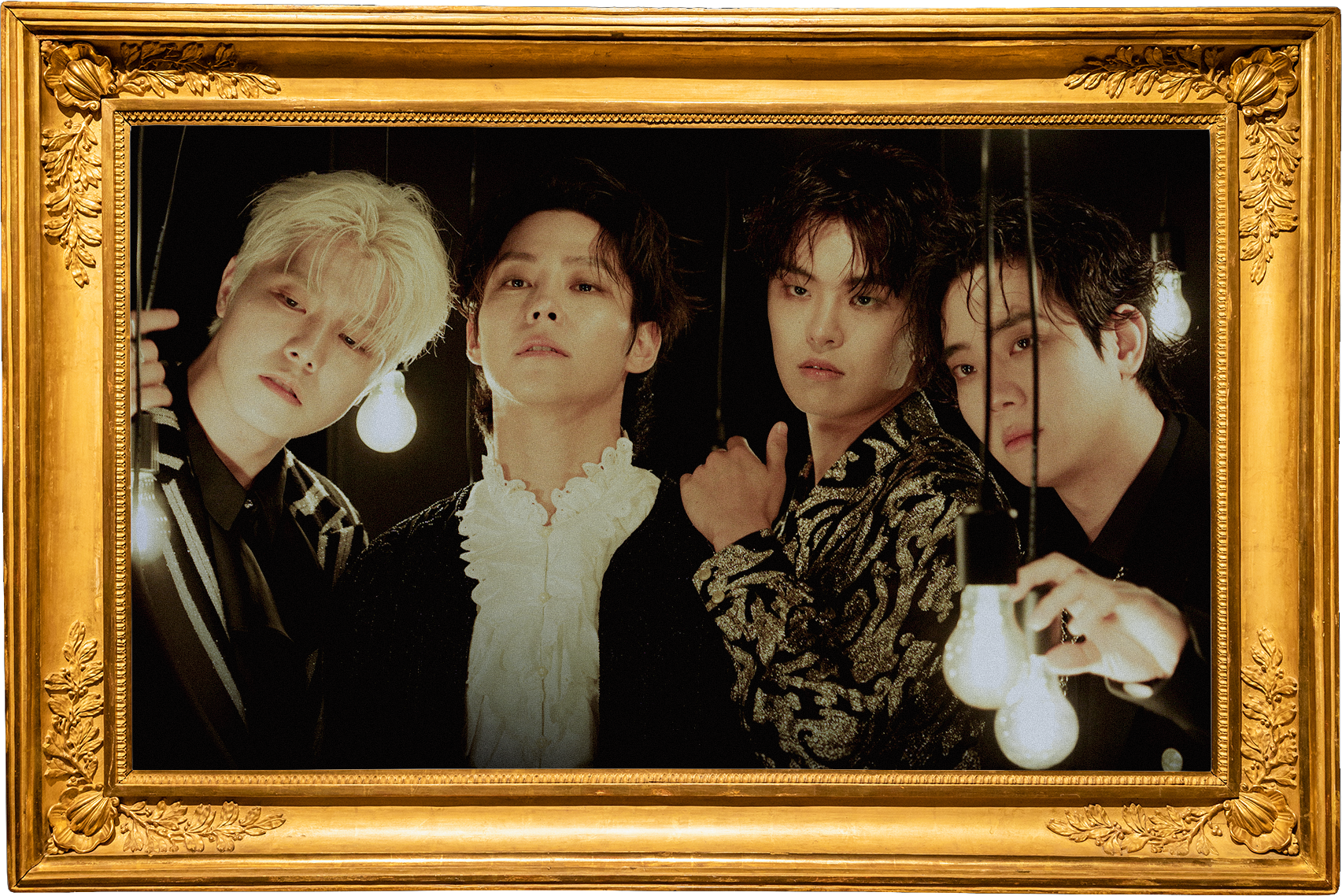 Four young men with styled hair wearing fashionable dark clothing, standing closely together in front of a black background with hanging light bulbs, framed by an ornate gold frame.