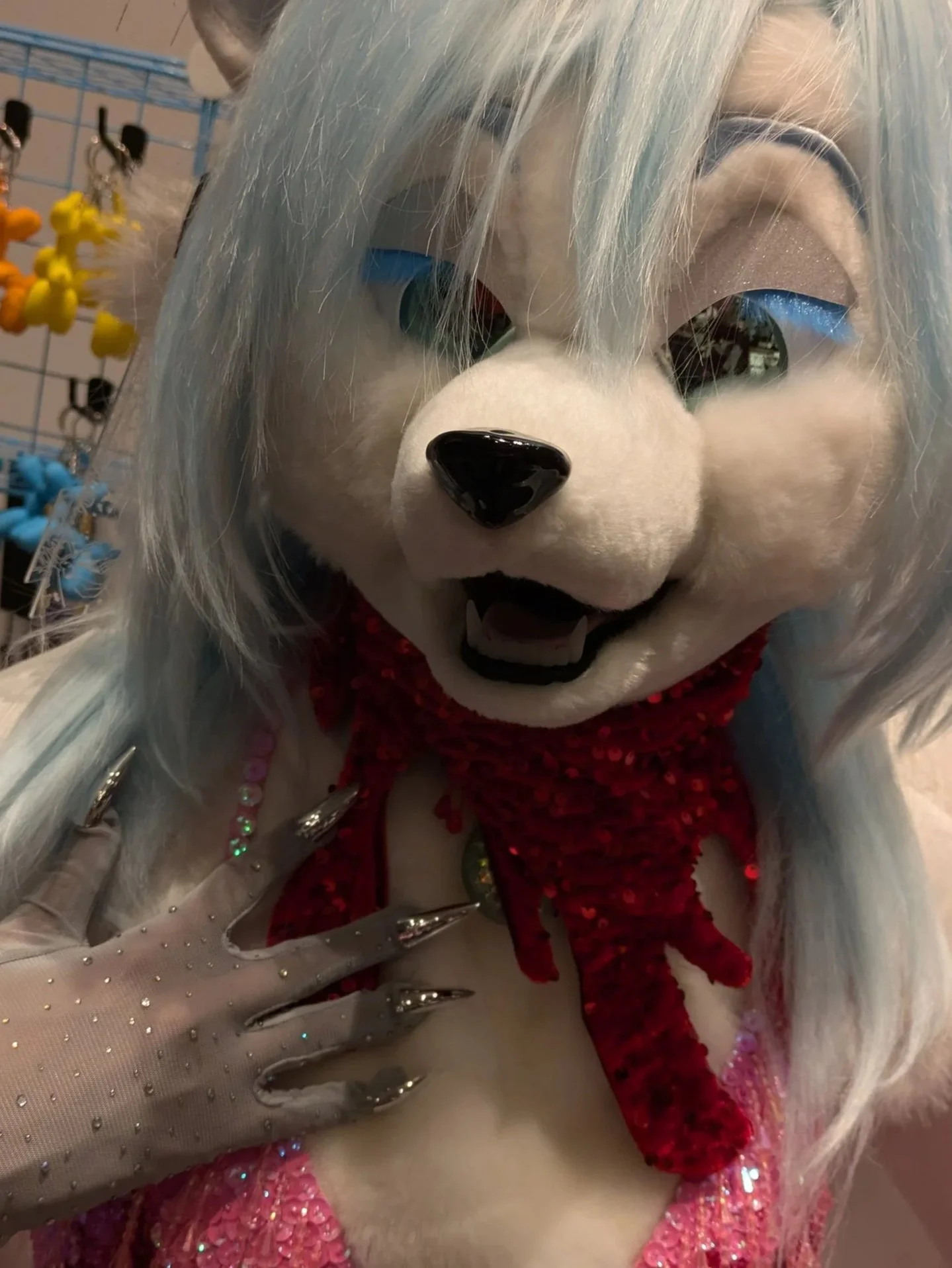 A fox fursuiter wearing a sparkly outfit and a blood splatter bandana
