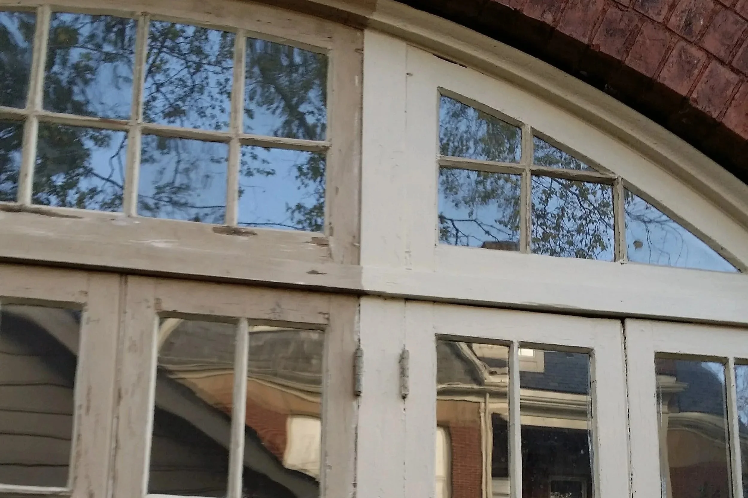 An image of an old historical window with water damage and rot, being repaired, sealed and protected