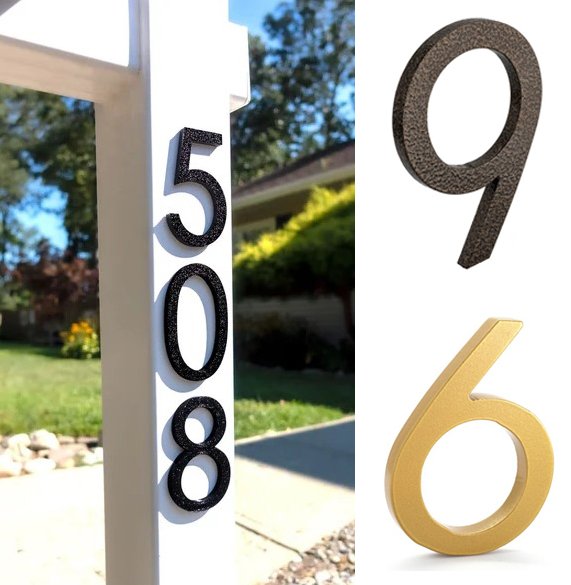 Close-up of house numbers 5088 in black, 9 in gray, and 6 in gold on a white post outside, with a background of a garden, trees, and a house.