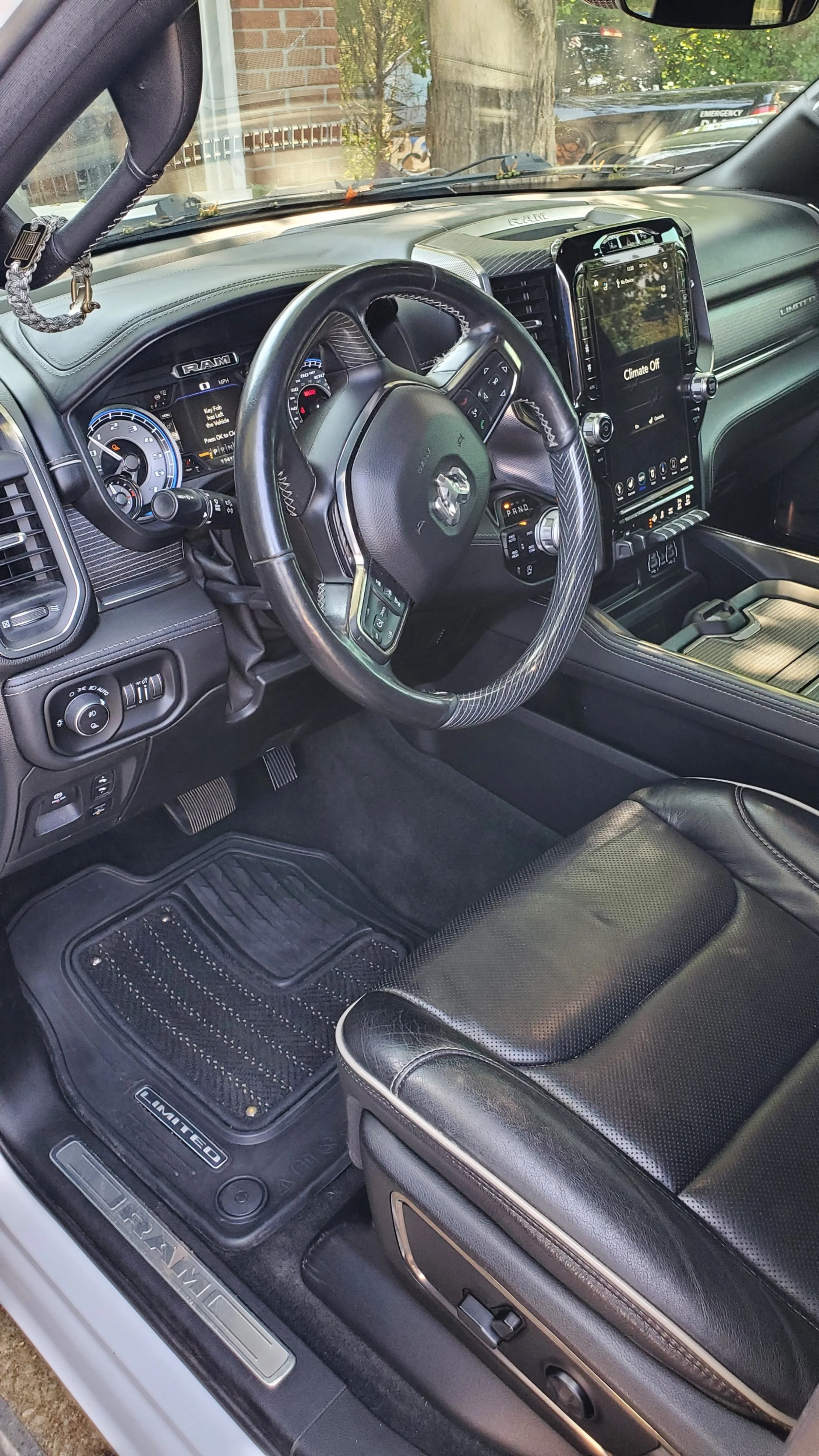 Interior of a RAM truck with a leather seat, steering wheel, dashboard, and center console.