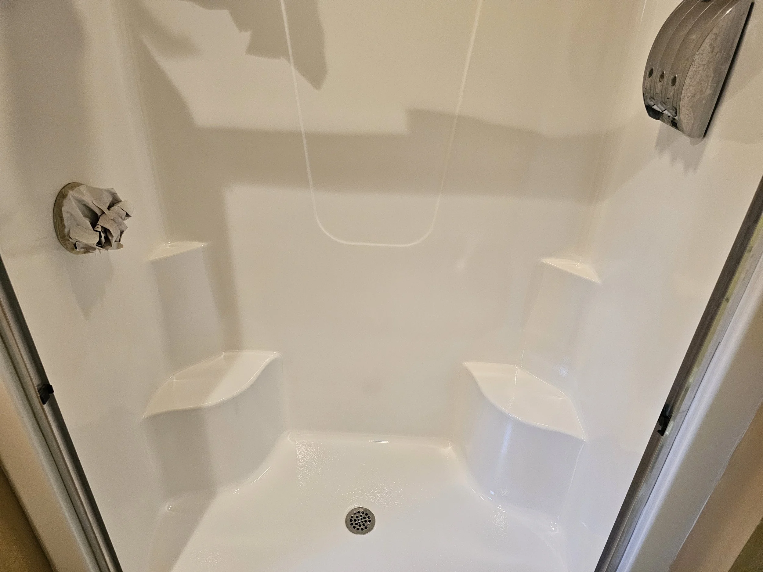 Refinished shower stall in white with slip resistant bottom. Cleaned shower stall and door.