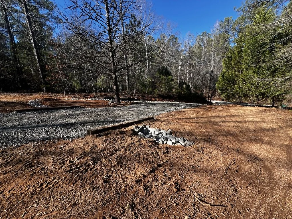 Leveling and grading of driveway base with gravel placement, preparing for compaction and surfacing by ASG Dirtworx.