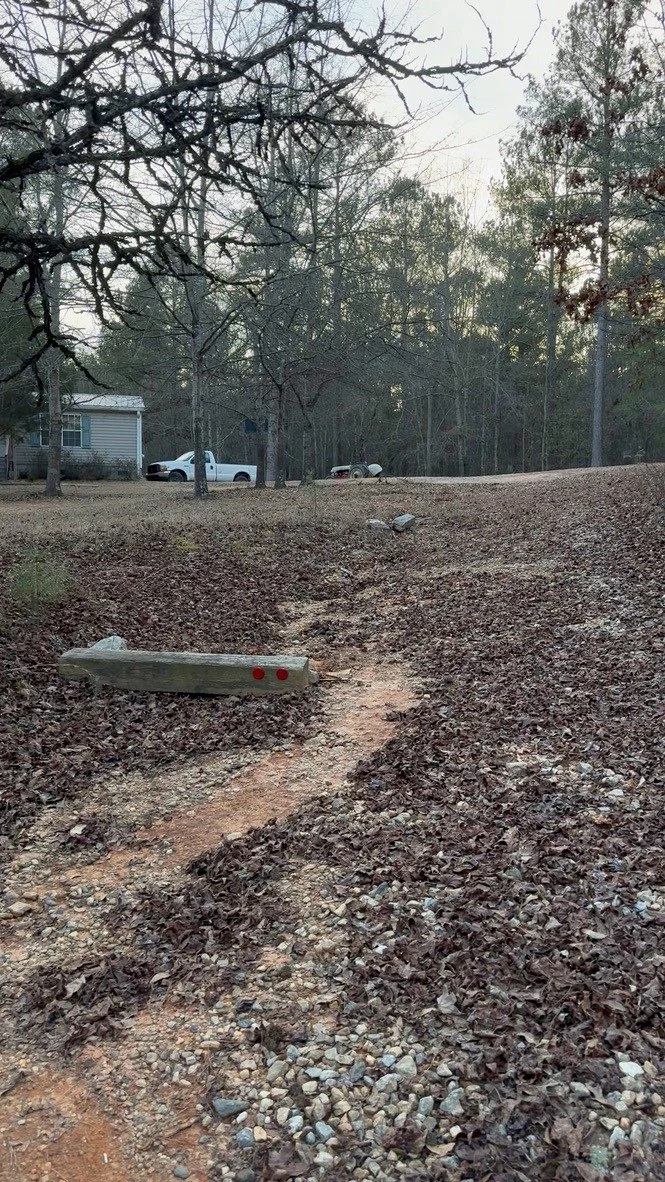 Driveway before repair showing soil erosion and runoff pathway near residence, documented prior to ASG Dirtworx intervention.