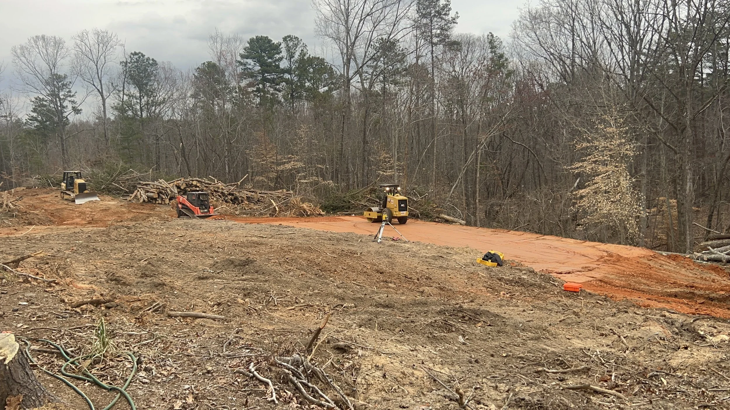 ASG Dirtworx crews performing soil compaction and grading with heavy equipment on a leveled land clearing project.