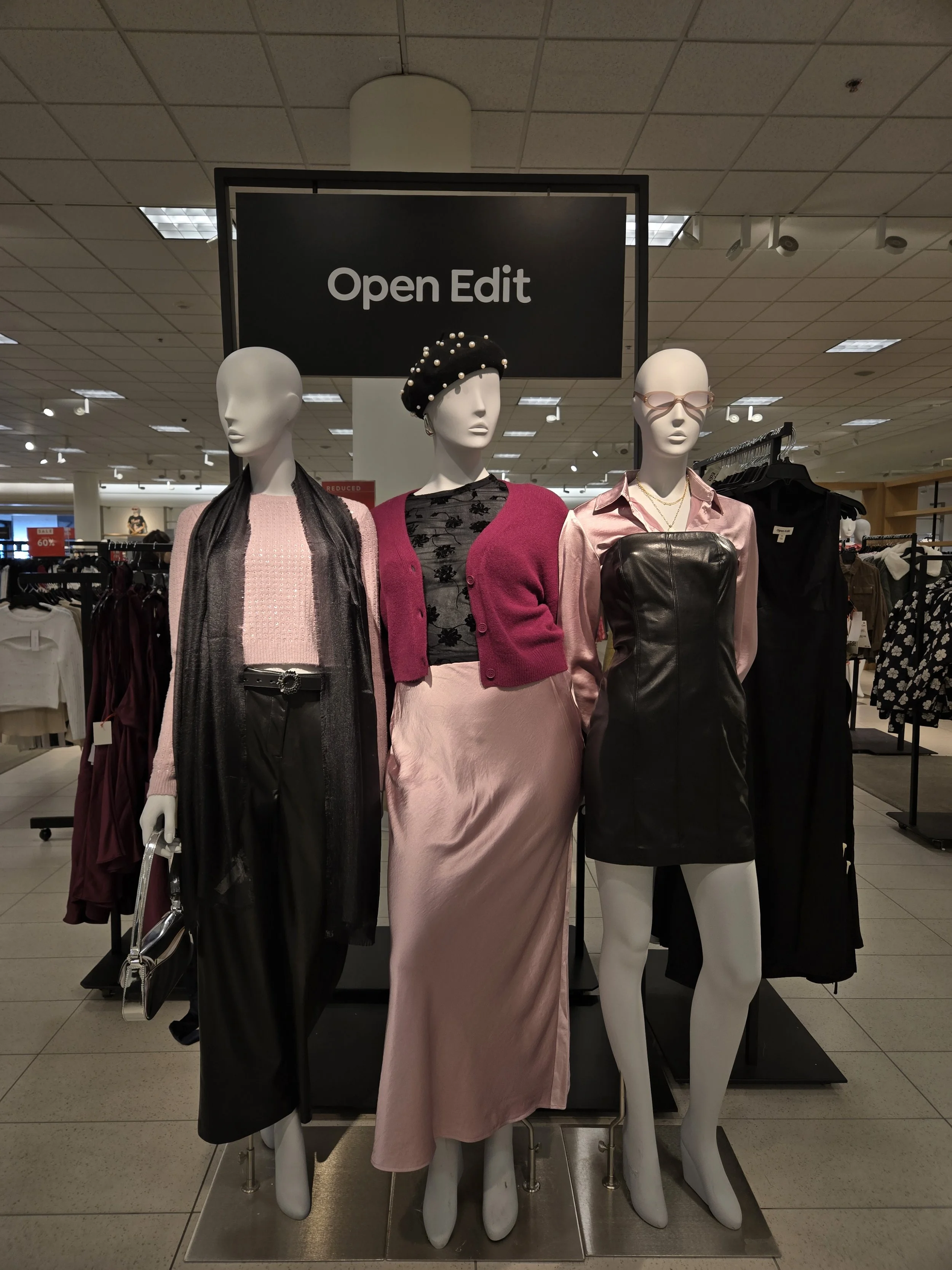 Hilary Biaku | Black Female Model, Creative Strategist, Content Creator, Public Speaker, and Life Coach —  Mannequins dressed in fashionable clothing inside a retail store with a sign overhead reading 'Open Edit'