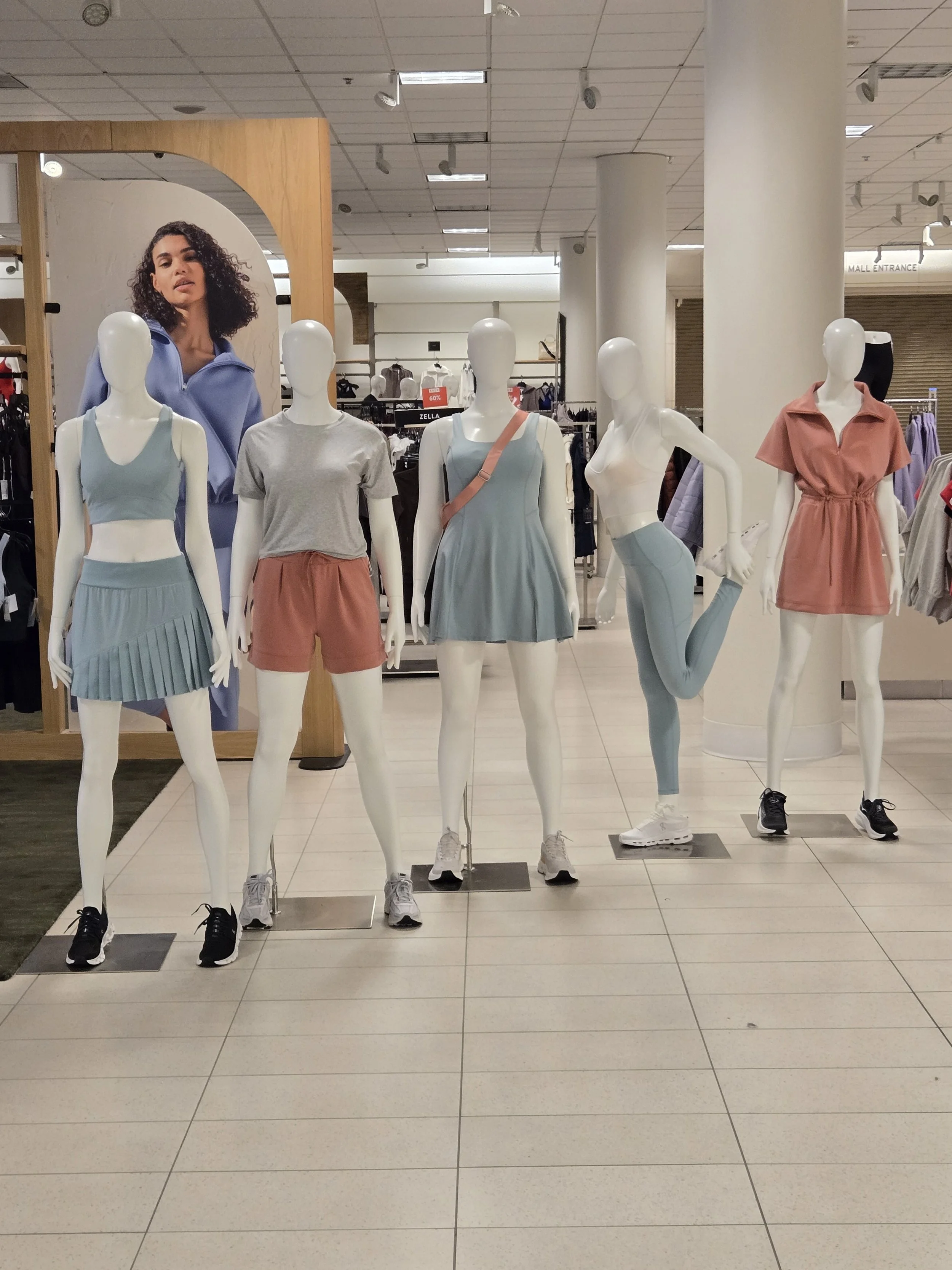 Hilary Biaku | Black Female Model, Creative Strategist, Content Creator, Public Speaker, and Life Coach —  Mannequins dressed in athletic wear and casual clothing in a retail store.