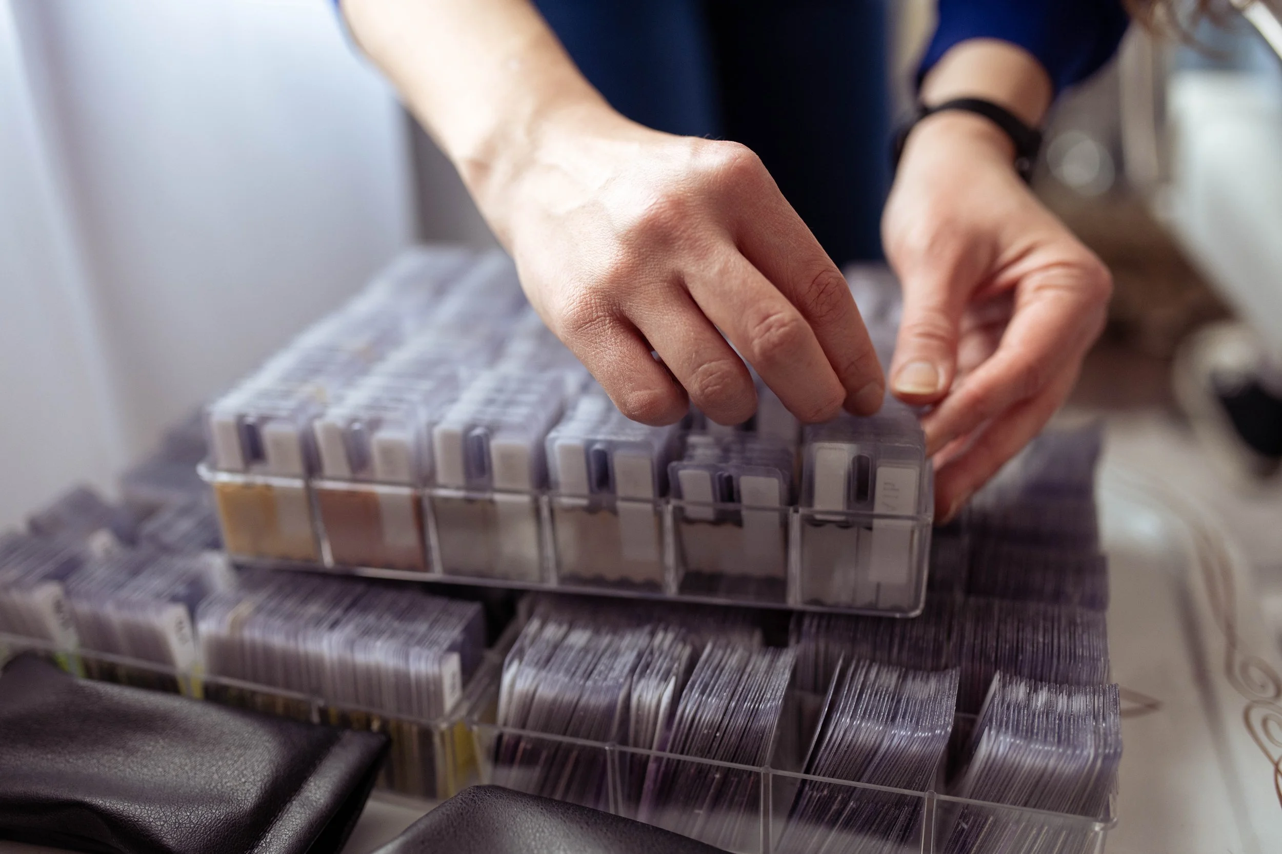 Elizabeth Reese-Lenz, founder of This Is Your Color, Color Analysis organizing small containers of fabric swatches used in color analysis in plastic storage boxes.