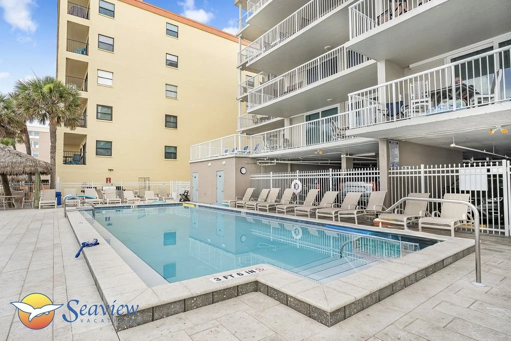 Outdoor heated pool and hot-tub with ample lounge chairs and umbrellas.