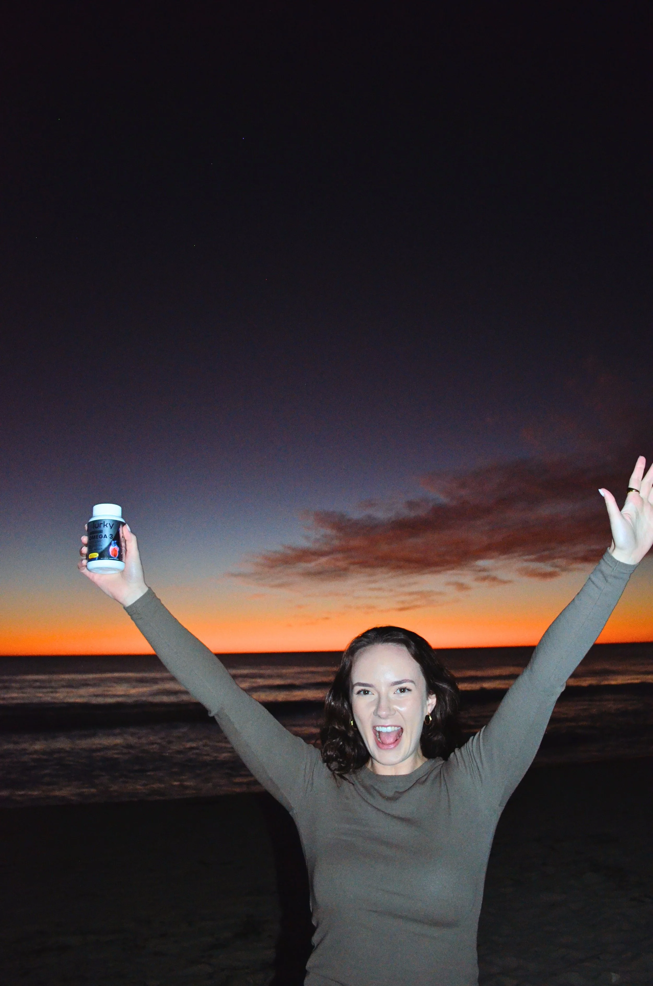 Golden hour branding shoot on the beach. Woman celebrating at sunset, symbolising confidence, freedom, and feminine empowerment through authentic storytelling By T.