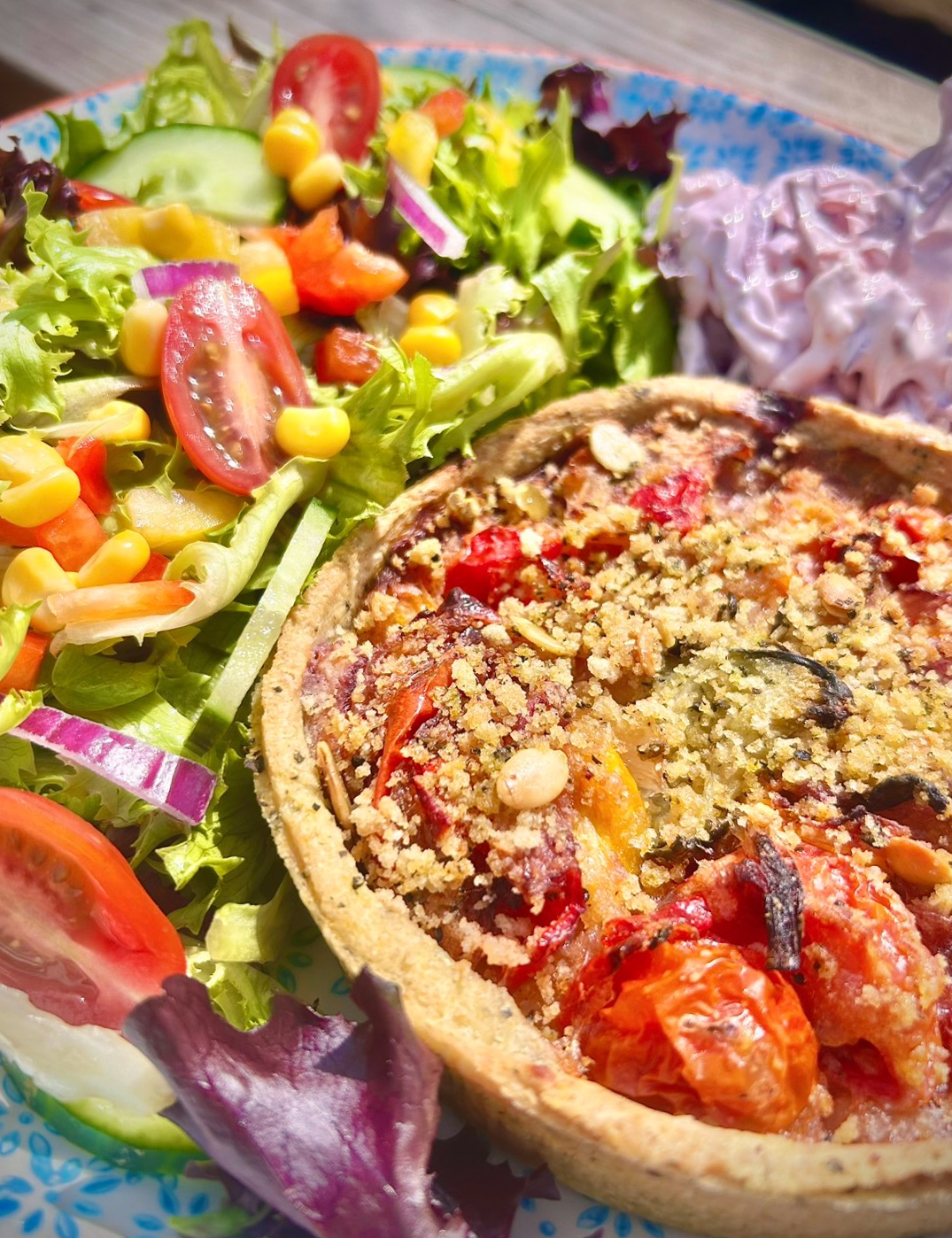 Food freshly prepared at Allerford Tea Room. Vegan Tart served with fresh salad and homemade coleslaw enjoyed in Exmoor Garden