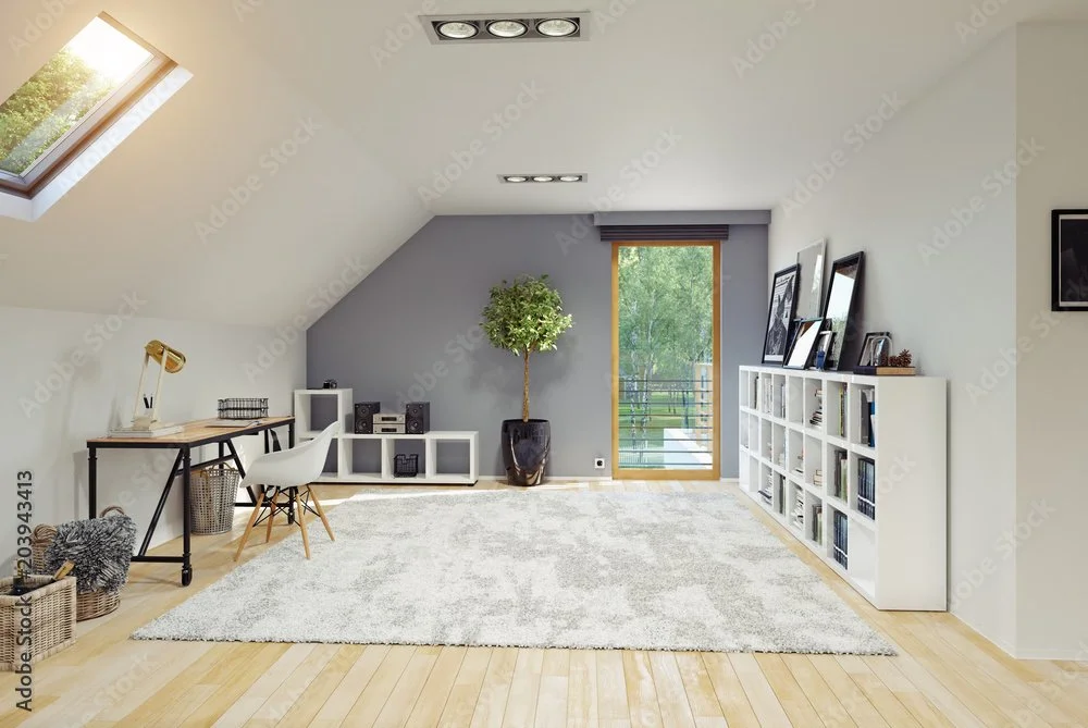Bright attic room with sloped ceiling, skylight, and balcony door, featuring a desk, white chair, shelves, a potted plant, and framed pictures.