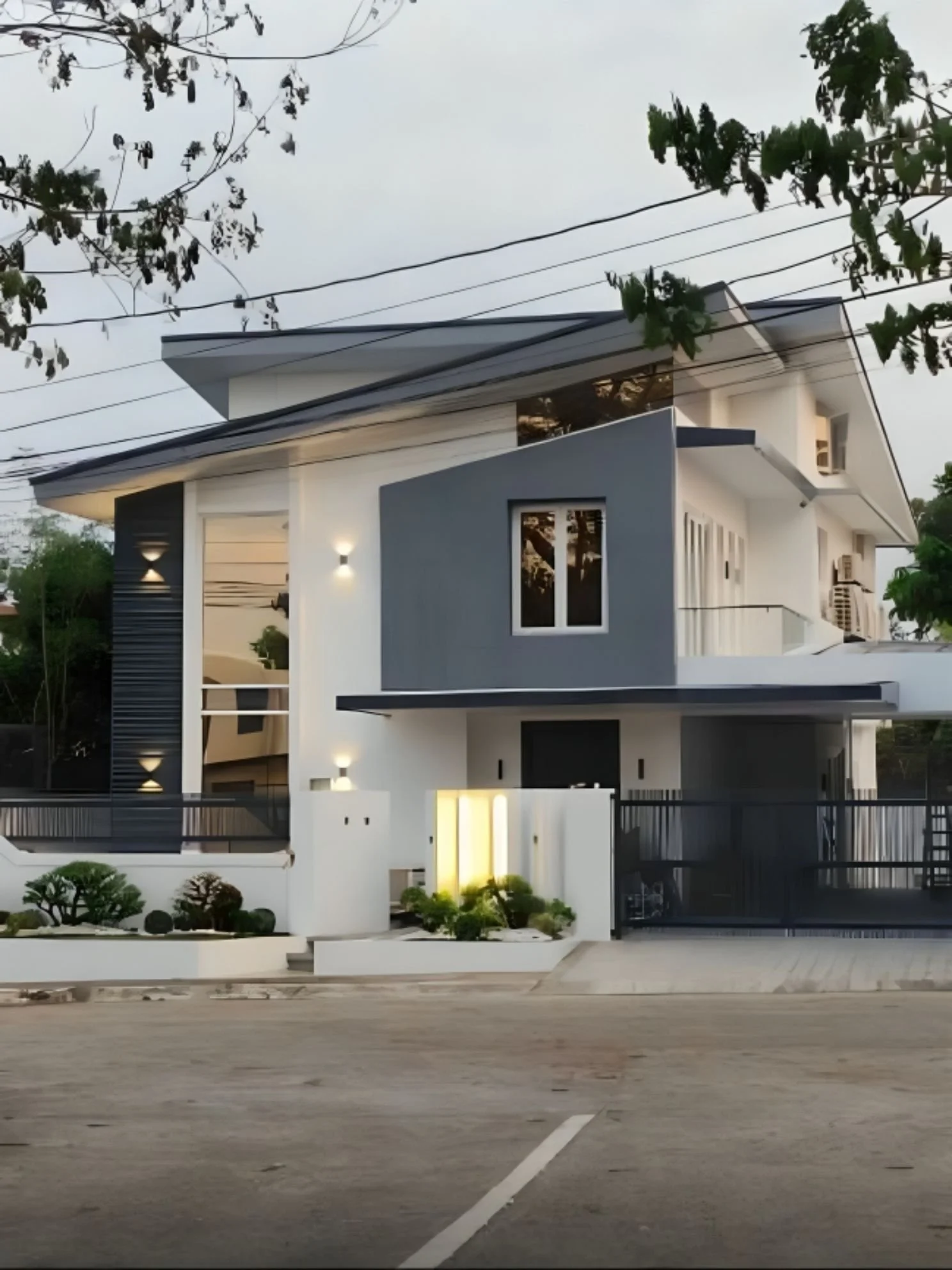 Modern multi-story house with white and gray exterior, large windows, and a gated driveway.