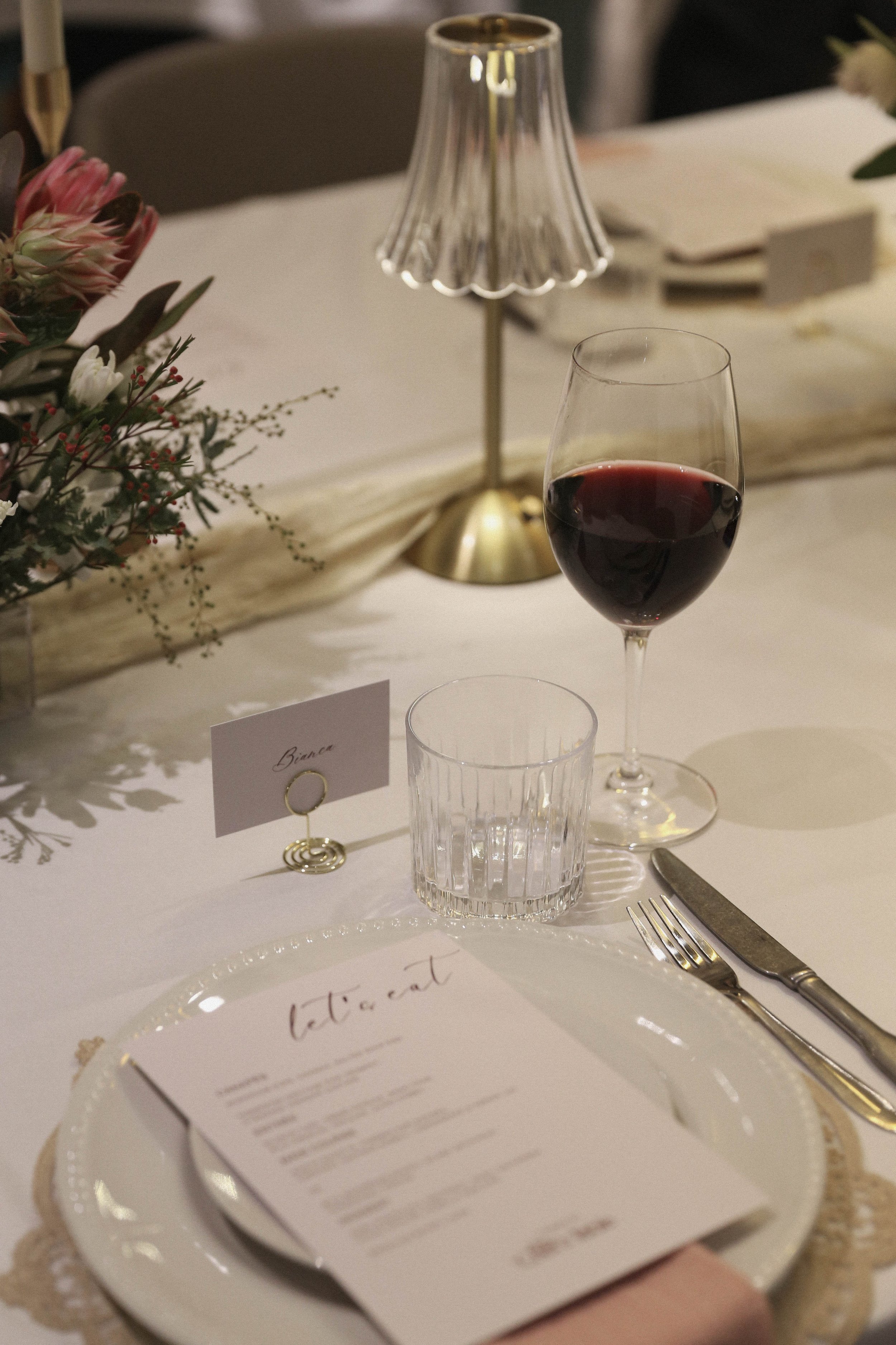 A dinner party table setting with wine and a menu.