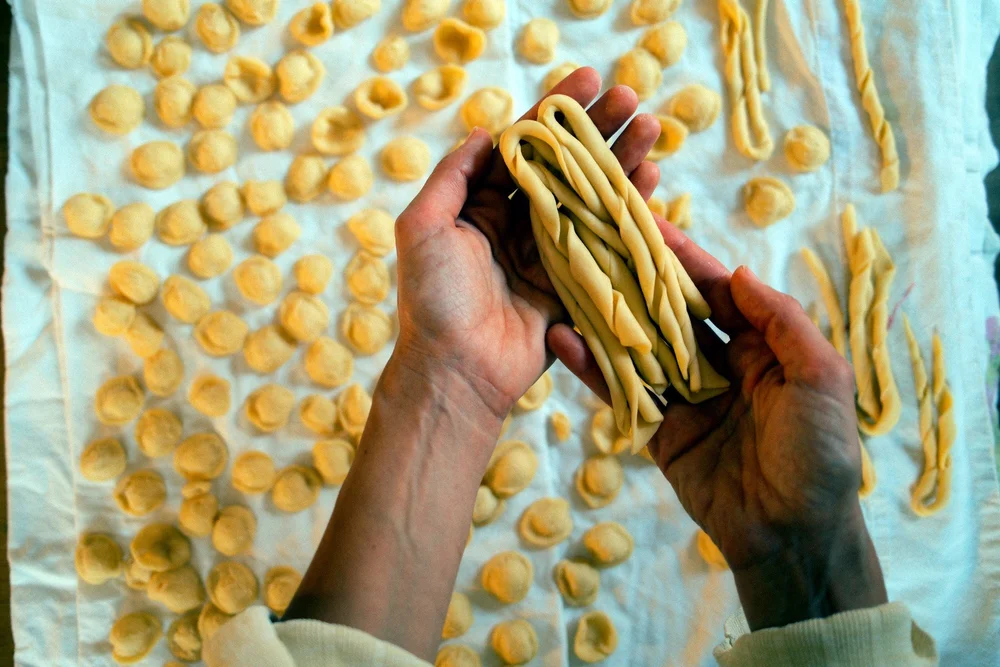 Hände mit frischen Friscidd über Orecchiette