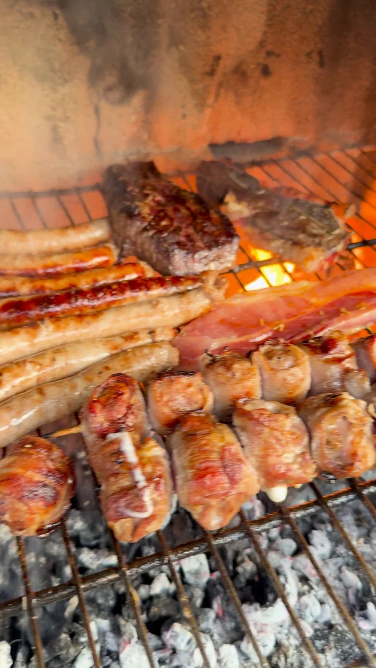 Salsiccia und Fleisch auf dem Holzkohlegrill der Villa