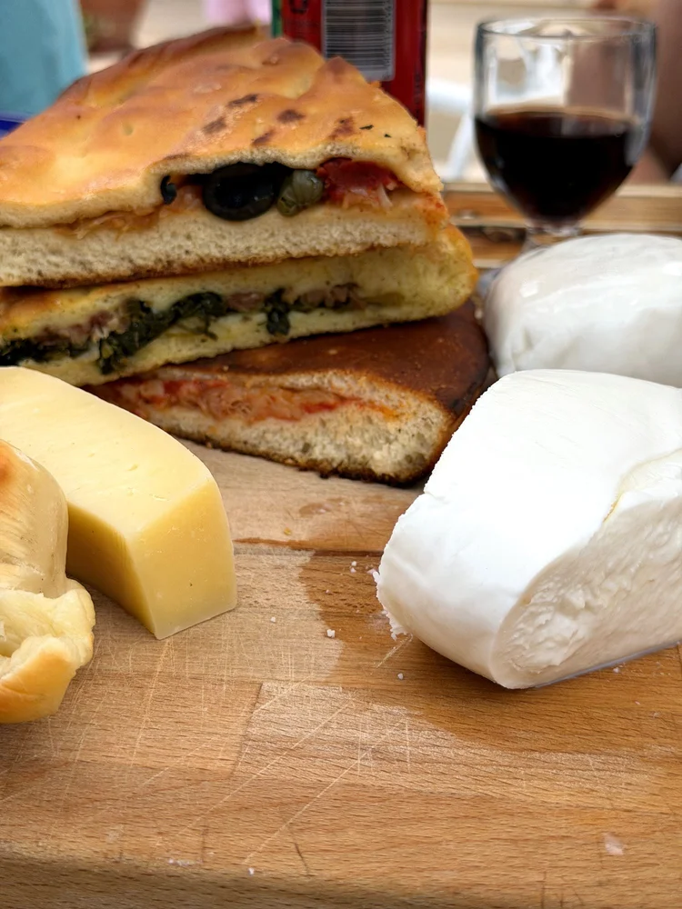 Puccia mit Oliven, dazu Mozzarella, Caciocavallo und ein Glas Rotwein
