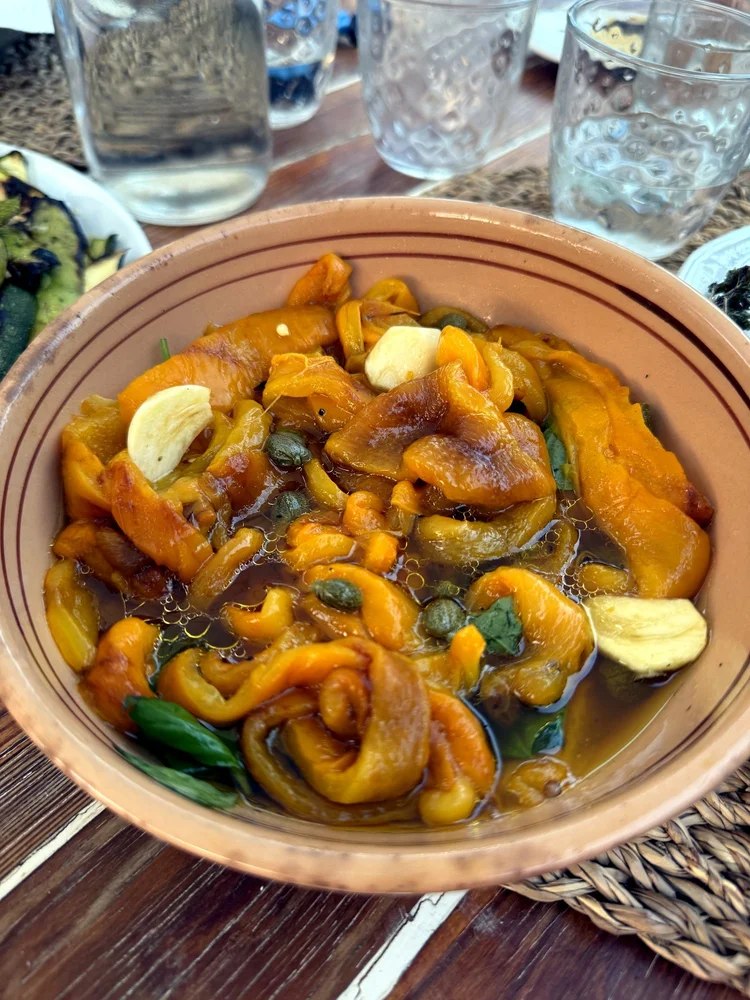 Peperonata in einer Tonschüssel auf dem gedeckten Tisch
