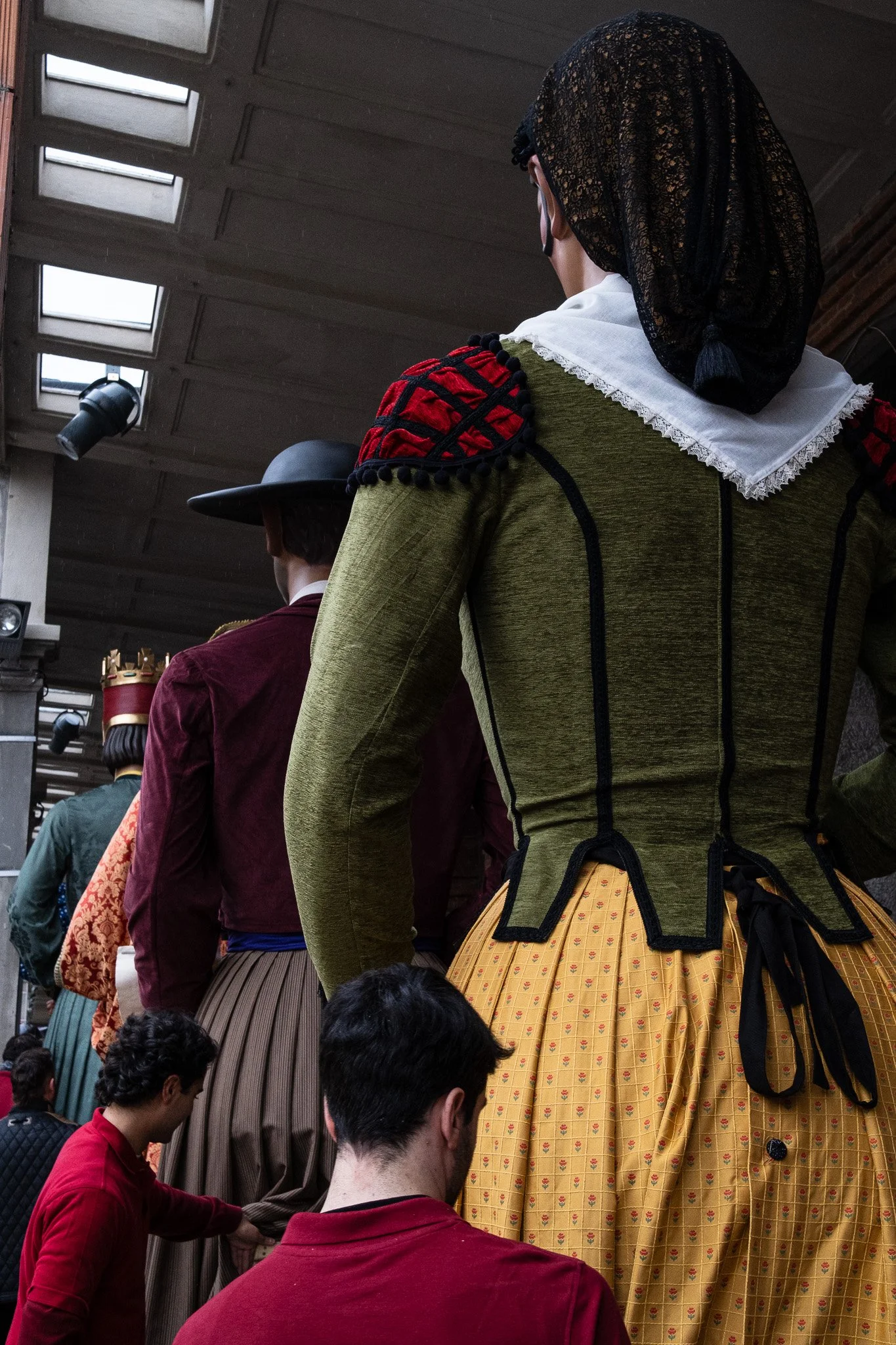 People dressed in traditional Spanish attire with elaborate, colorful costumes and accessories, possibly for a festival or celebration.