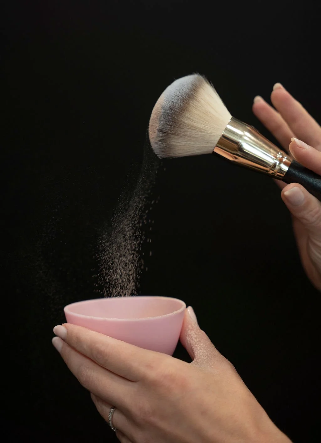 Finishing powder being applied during a custom spray tan appointment.