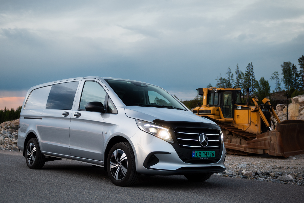 Silver Mercedes-Benz van parked on the side of a road with construction equipment and rocks in the background under a cloudy sky.