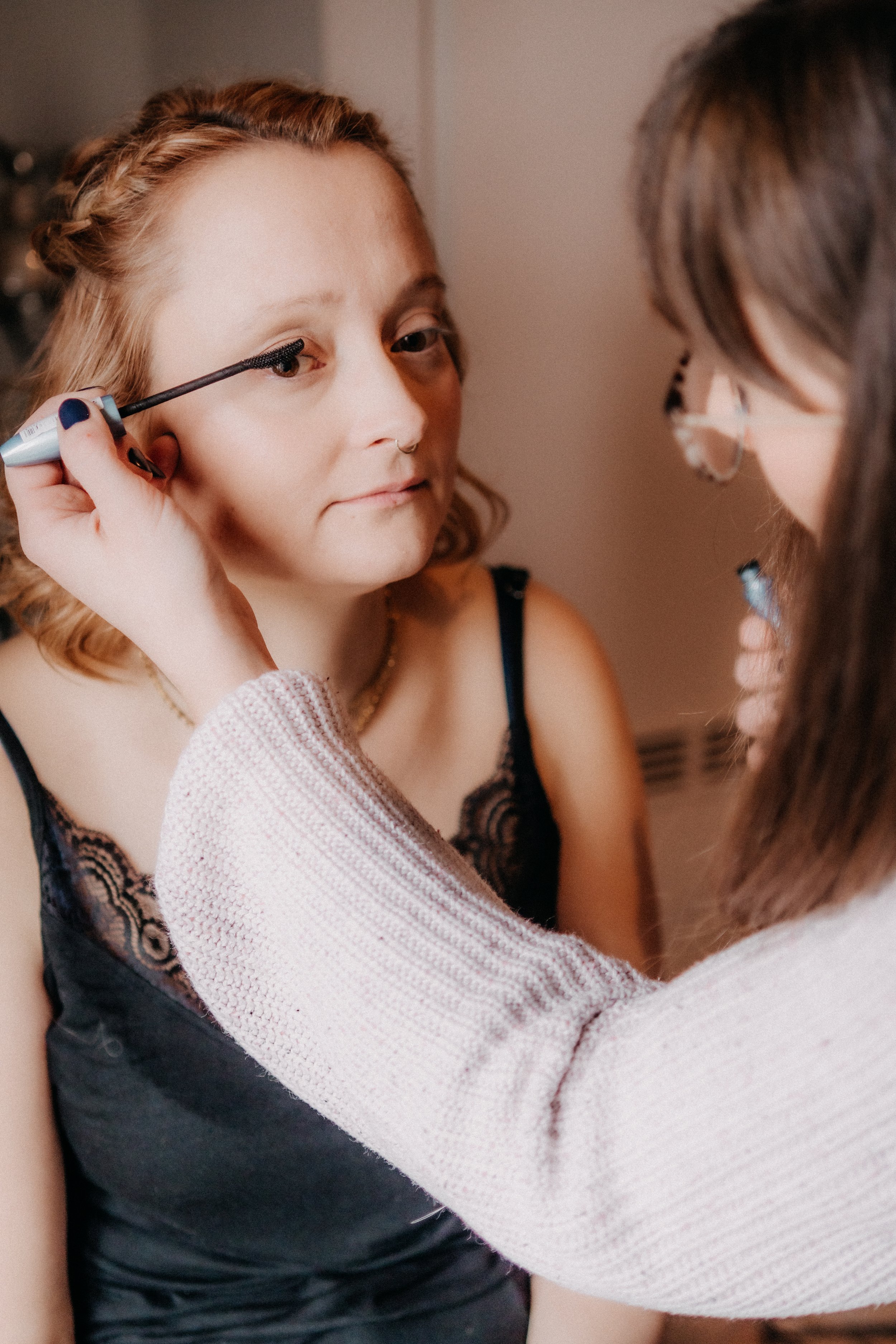 Eine Frau wird geschminkt, indem sie Augen-Make-up aufträgt.